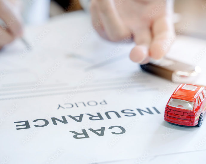 Car insurance policy with red car toy and blur image of man hand